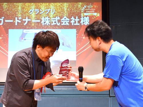 ＧＭＯメイクショップの古屋智久ＣＯＯ（写真右）がガードナーの常務取締役　関秀平氏に表彰盾などを授与