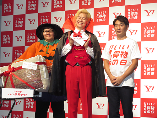 「いい買い物の日」キックオフイベントに登壇した谷田智昭執行役員（右）とお笑いタレントのメイプル超合金